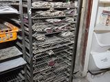 a metal rack with many trays of food inside of it