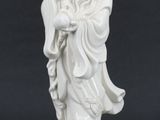 une figurine blanche représentant un homme tenant un oiseau sur un rocher