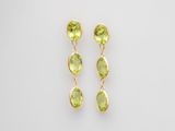 une paire de boucles d'oreilles en péridot vert sur fond blanc