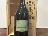 une bouteille de vin posée sur une table à côté d'une caisse en bois