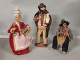 trois figurines représentant des personnes vêtues de costumes traditionnels et coiffées de chapeaux traditionnels