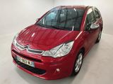 Une Citroën rouge est garée dans une pièce blanche