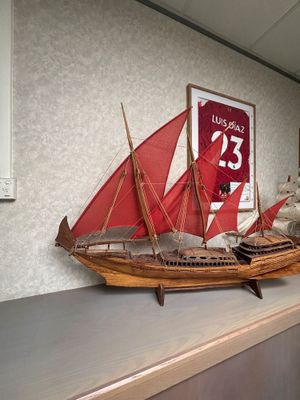 une maquette en bois d'un voilier posée sur une étagère