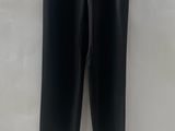 a black leather pants hanging on a hanger on a wall