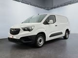 La camionnette blanche est garée dans une grande pièce.