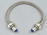 a close up of a silver bracelet with blue beads on it