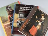 trois livres posés sur une table blanche, avec la photo d'un homme et d'une femme
