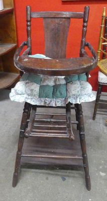 a wooden high chair with a blue and white cloth on it