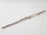 an old silver flute with a wooden handle on a white surface
