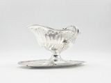 an antique silver plate with a glass saucer on it