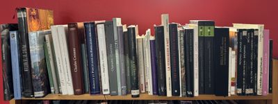 many books that are on a book shelf in the room
