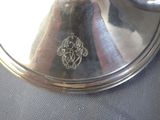a silver plate with a silver handle on a table