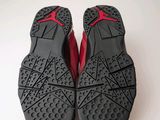 the soles of a pair of black and red shoes on a white surface