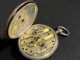 a pocket watch that is sitting on a black surface