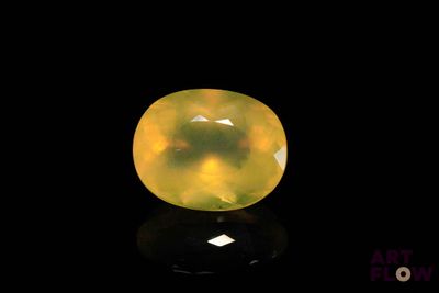 a yellow jade stone on a black surface