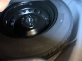 someone is holding a black tire with a black rim on it