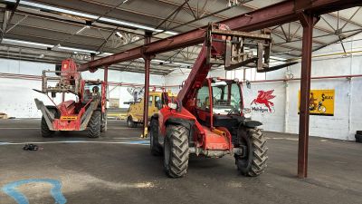 deux tracteurs rouges garés à l'intérieur d'un grand bâtiment