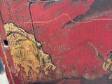 a red box with a painting on it sitting on the ground