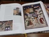 un livre ouvert posé sur une table, avec des images dessus