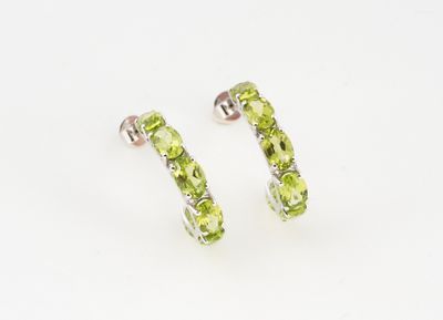 une paire de boucles d'oreilles ornées de péridots sur fond blanc