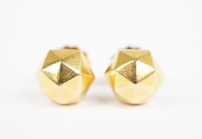 a pair of gold stud earrings on a white background