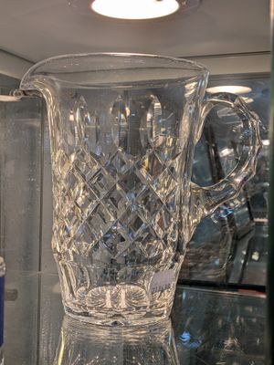 un pichet en verre posé sur une étagère en verre