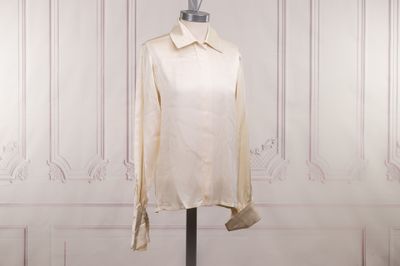 an image of a white shirt on a mannequin stand in front of a white wall