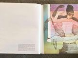 an open book with a picture of a woman sitting on a chair