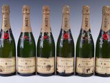 six bottles of champagne are lined up in a row
