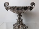 a silver bowl sitting on a clear glass table