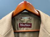 un manteau suspendu à un cintre sur lequel est accrochée une étiquette avec un nom
