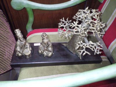 quelques figurines en argent sont posées sur un plateau noir, posé sur une chaise