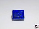 a close up of a square blue stone on a white surface