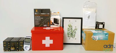 une boîte rouge ornée d'une croix blanche, à côté d'autres articles