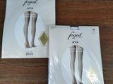 Deux paires de bas moulants sont posées sur une table, accompagnées d'une étiquette de prix.
