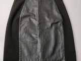 une jupe en cuir noir et gris accrochée à un mur