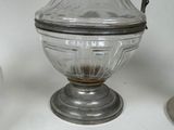 a glass jar with a metal handle on a table