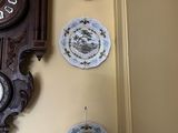beaucoup d'assiettes accrochées au mur à côté d'une horloge