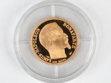 the gold coin is in a clear plastic holder on a white surface
