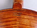 a close up of the back of a violin with a label on it