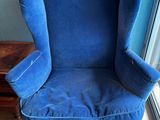 a blue chair that is sitting in front of a window