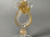 a glass candle holder with a gold flower on it