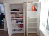 a white cabinet with a door open in a room