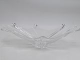 un saladier en verre transparent posé sur une table blanche, avec un fond blanc