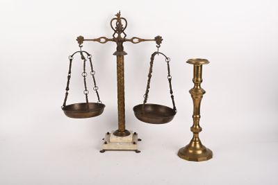 une balance sur laquelle sont posées deux bougies et un bougeoir