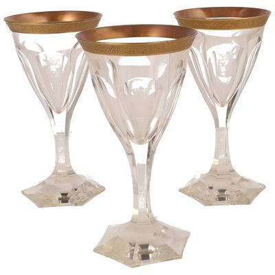 trois verres à vin transparents avec des bords dorés sur fond blanc