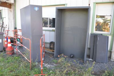 a small building with a metal door and a metal fence