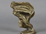 an antique bronze statue of a woman with her hair blowing in the wind