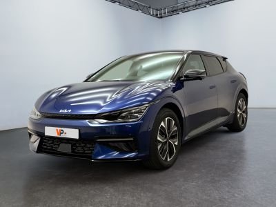 La voiture bleue est garée dans une grande pièce aux murs blancs