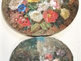 two plates with flowers painted on them sitting on a table